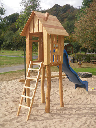 Spielturm aus Robinie und Lärche mit blauer Rutsche für private Plätze