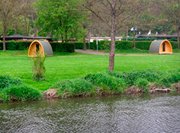 Attraktives Foto von 2 Hobbit-Homes auf der grünen Wiese eines Campingplatzes