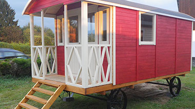 Ein roter Holzbauwagen steht in unserer Ausstellung in Eitorf